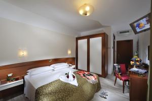 Habitación de hotel con cama con mesa y silla en Hotel Eden en Bibione
