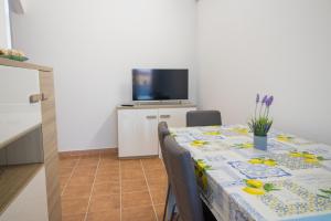 una sala da pranzo con tavolo e TV di Casa Wendy a SantʼAntìoco