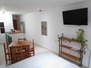 Habitación con cama, mesa y TV. en Departamento Centrico Ana en Ushuaia