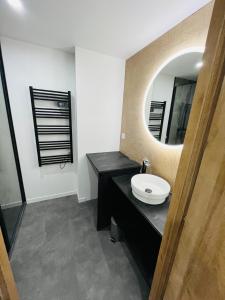 a bathroom with a sink and a mirror at Charmante Maison en Pierre - Centre Ville - Plage in Ouistreham +15 photos