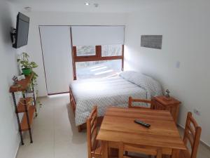 una pequeña sala de estar con una mesa y una cama en Departamento Centrico Ana en Ushuaia