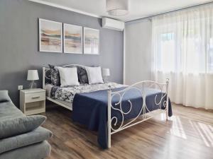 a bedroom with a bed and a couch and a window at Levante - 500m Amphitheatre - free parking in Pula