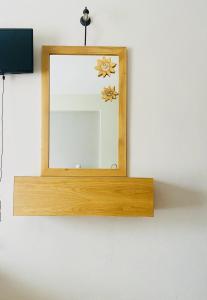 a mirror with a wooden frame on a wall at Harmony Seaside Pelion in Platanias