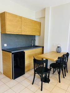 a kitchen with a wooden table and black appliances at Harmony Seaside Pelion in Platanias