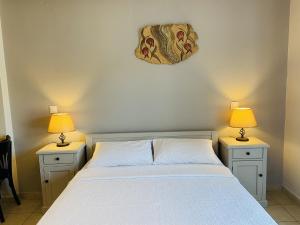 a bedroom with a bed with two lamps on both sides at Harmony Seaside Pelion in Platanias