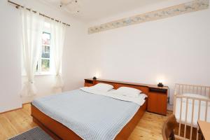 a white bedroom with a bed and a window at Casa Santo e Albina Rabac in Rabac