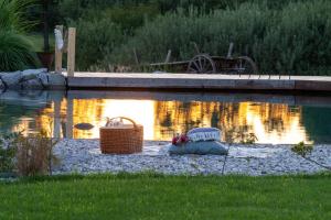 ein Blumenkorb neben einem Teich in der Unterkunft Glamping Happiness - Natural Pool & Wellness in Ribnica