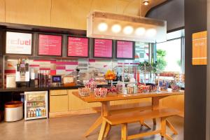 a restaurant with a counter with a table and chairs at Aloft Ontario-Rancho Cucamonga in Rancho Cucamonga