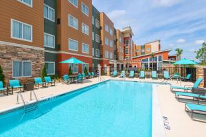 an image of a pool at a hotel with chairs and umbrellas at Residence Inn by Marriott Spartanburg Westgate in Spartanburg