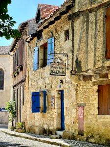 un viejo edificio de piedra con un cartel. en Le Colombier de Cyrano et Roxane, en Bergerac