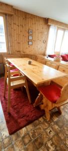 a wooden table with a chair and a wooden bench at Appartement au pied des télécabines in La Tzoumaz +4 photos