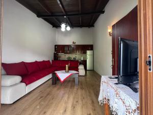sala de estar con sofá rojo y mesa en Guest House Vjosa en Përmet