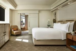 sypialnia z dużym białym łóżkiem i krzesłem w obiekcie The Ritz-Carlton, Denver w mieście Denver