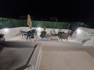 een patio met een tafel en stoelen in de nacht bij Casette di Alex con TERRAZZA in Trapani