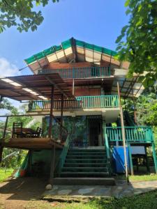 ein großes Haus mit einer Treppe und einem Balkon in der Unterkunft Ecohotel Bahía Terco in Nuquí