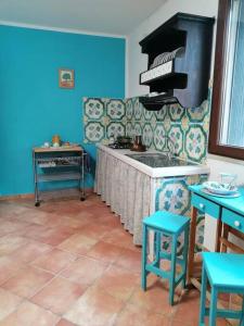 una cucina con pareti blu e forno a piano cottura di Casa Tequi a 200mt dal mare a Terrasini
