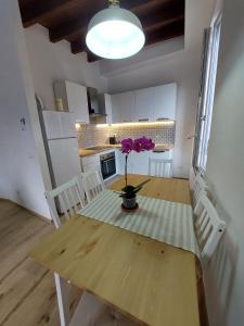 uma cozinha com uma mesa de madeira com um vaso de flores em DA me MAE em La Spezia