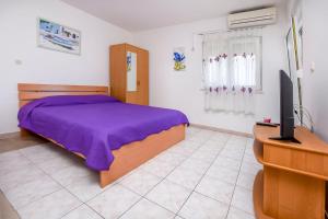 een slaapkamer met een bed, een tv en een bureau bij Apartments Antea in Rogoznica