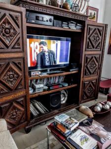 uma sala de estar com televisão num centro de entretenimento em madeira em B&B - El Refugio -C D em Paraná