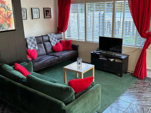 ein Wohnzimmer mit 2 Sofas und einem TV in der Unterkunft Het Pronkje in Renesse