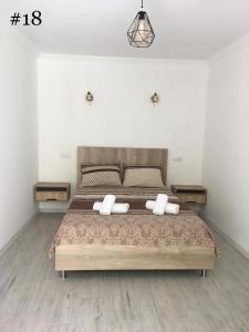 ein Schlafzimmer mit einem großen Bett mit zwei Kissen in der Unterkunft Rezo's House in Kwariati
