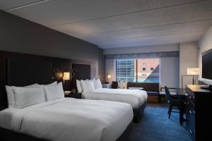 a hotel room with two beds and a desk at The Baronette Renaissance Detroit-Novi Hotel in Novi