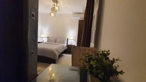 Un dormitorio con una cama y una mesa con una planta en IRIS Apartments, en Bitola