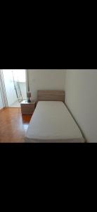 Appartamento Verde في أوديني: غرفة نوم بسرير ابيض وارضية خشبية