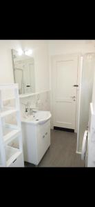 uma casa de banho branca com um lavatório e um espelho em Appartamento Verde em Udine