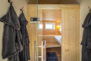 uma casa de banho em madeira com um chuveiro e uma banheira em Riedbach-Lodge em Viechtach