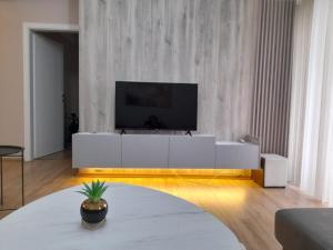 a living room with a tv on a white cabinet at Centar two apartment in Skopje