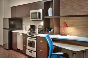 una cocina con una mesa y una silla azul. en TownePlace Suites by Marriott Clovis, en Clovis