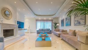 un soggiorno con divano e camino di Crown Royal Luxury Villa Estates a Città di Rodi