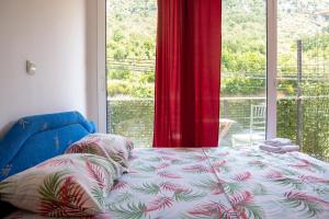 a bedroom with a bed and a large window at Family Apartments Vukcevic in Čanj