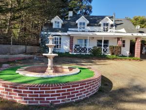 a brick fountain in front of a house at Algarrobo Casa Campo ALYWEN in Algarrobo