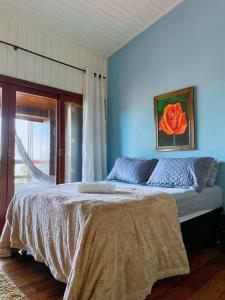 1 dormitorio con 1 cama grande y pared azul en Casa do Mirante quarto 303 en Florianópolis