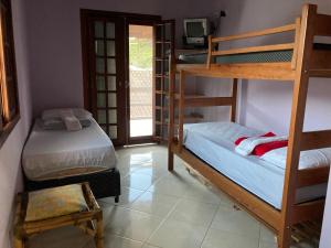 a room with two bunk beds and a television at Hostel Re & Mar in Caraguatatuba