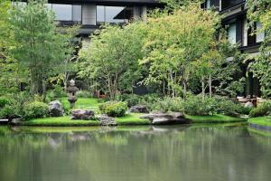 HOTEL THE MITSUI KYOTO, a Luxury Collection Hotel & Spa في كيوتو: حديقة فيها بركه امام مبنى