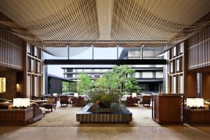 a lobby with a large room with tables and chairs at HOTEL THE MITSUI KYOTO, a Luxury Collection Hotel & Spa in Kyoto