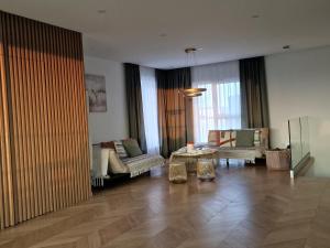 a living room with two couches and a table at Luxury Penthouse Rzeszów in Rzeszów