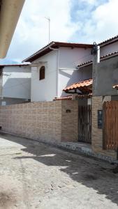 a house with a brick wall and a fence at Casa da Ilha de Boipeba in Ilha de Boipeba