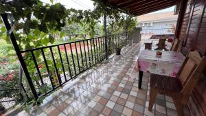 un balcón con mesa y bancos. en Apart Nicolas, en Puerto Iguazú