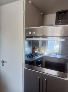 una cucina con piano cottura e forno di Mobil-home FO 30 à VIAS a Vias