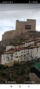 un edificio en la cima de una colina con un castillo en Casa Enry, en Alcalá de la Selva