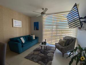 sala de estar con sofá azul y silla en Almar 303 en Cerritos cerca de la playa!, en Mazatlán