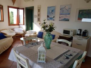 a living room with a table with a vase of flowers on it at CASA MAESTRALE - Vista mare Pittulongu - Sardegna - IUN R2217 in Olbia +23 photos