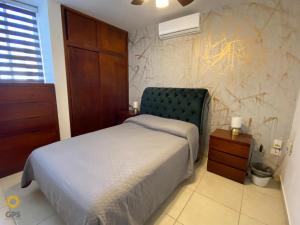 1 dormitorio con 1 cama con cabecero verde en Almar 303 en Cerritos cerca de la playa!, en Mazatlán