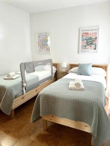 1 dormitorio con 2 camas y toallas. en Elena Playa Sol, en Alcudia