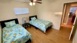 1 Schlafzimmer mit 2 Betten und einem Deckenventilator in der Unterkunft Delightful 3 Bdrm Home, Mins to Clearwater Beach in Clearwater
