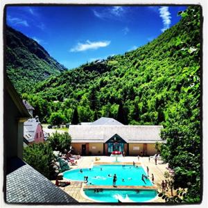 a large swimming pool in front of a mountain at Chalet Sanset in Gèdre
